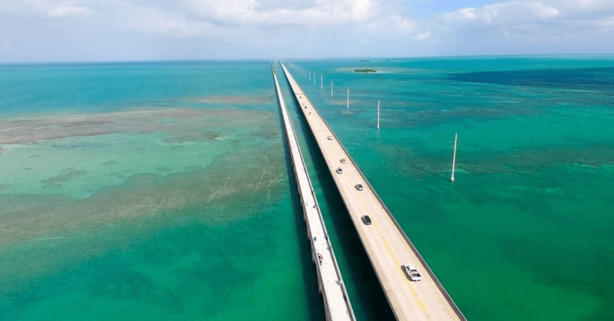 Aerial View Of The Overseas Highway With Cars Surrounded By Sea.