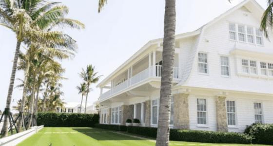 Elegant beachfront house with extensive backyard and palm trees