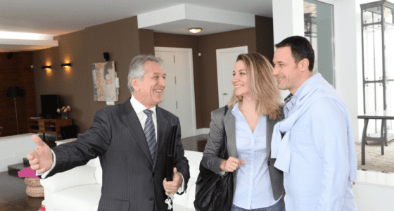 Real estate agent showing modern house to couple